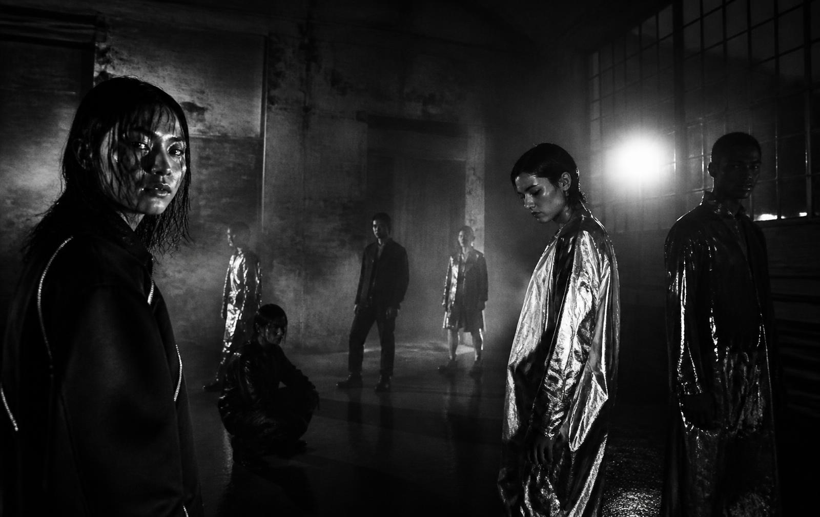 Creatives gathered in an industrial loft under a single hard light